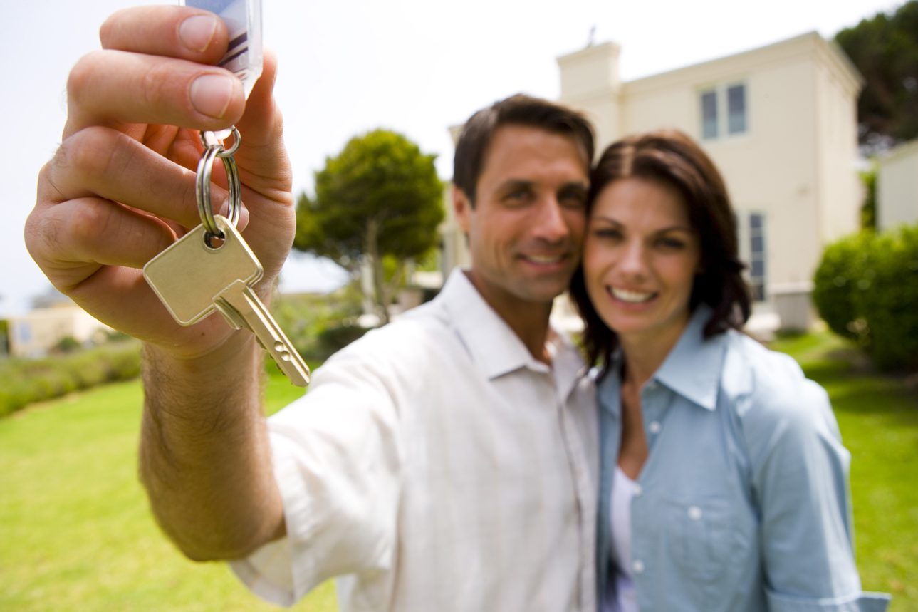first time home buyers standing outside new york house with sold sign real estate closing process attorney guidance